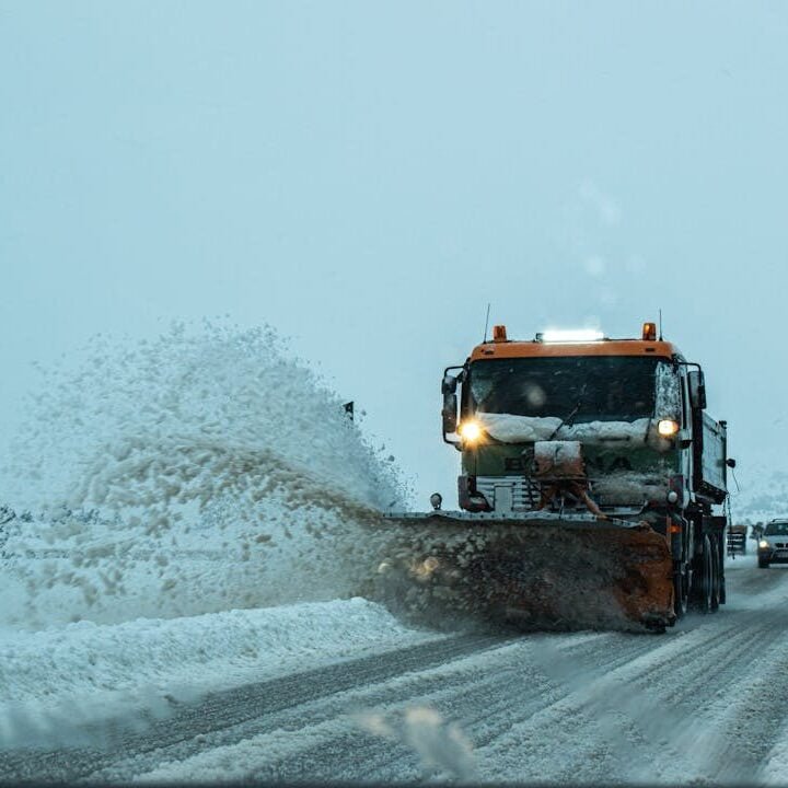 snow plow removing ice and snow from highway